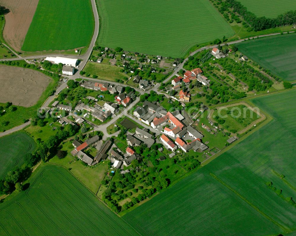 Untitz from above - Agricultural land and field boundaries surround the settlement area of the village in Untitz in the state Thuringia, Germany