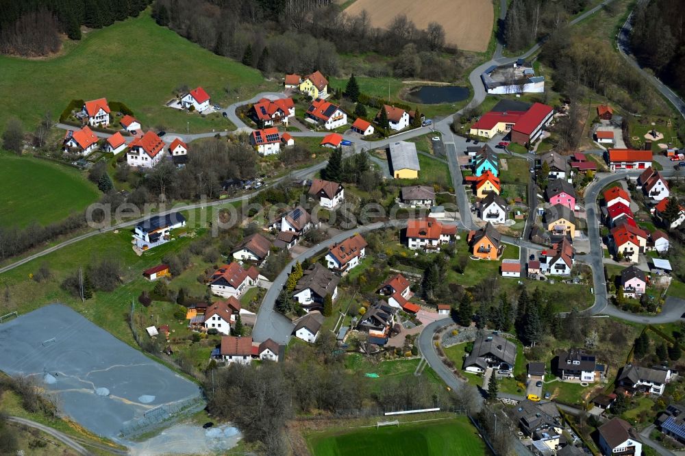 Wartenfels from above - Agricultural land and field boundaries surround the settlement area of the village in Wartenfels in the state Bavaria, Germany