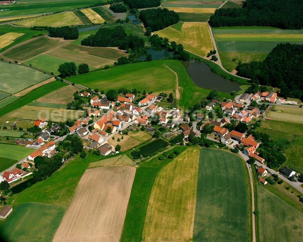 Weiherschneidbach from above - Agricultural land and field boundaries surround the settlement area of the village in Weiherschneidbach in the state Bavaria, Germany