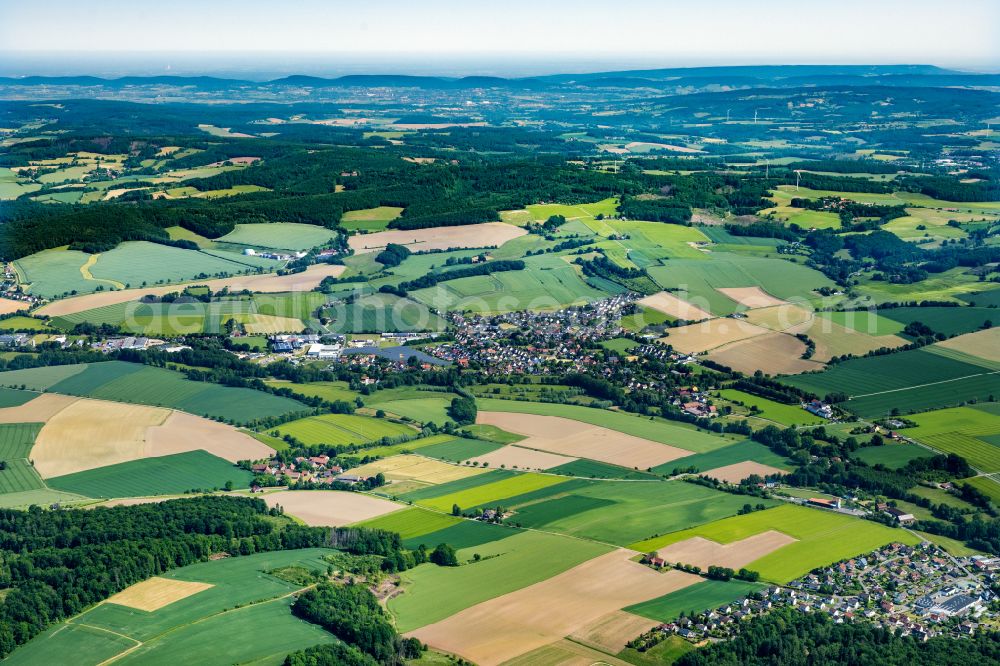 Aerial photograph Dörentrup - Agricultural land and field boundaries surround the settlement area of the village in Wendlingshausen on street Am Schloss in Doerentrup in the state North Rhine-Westphalia, Germany