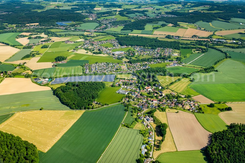 Dörentrup from above - Agricultural land and field boundaries surround the settlement area of the village in Wendlingshausen on street Am Schloss in Doerentrup in the state North Rhine-Westphalia, Germany