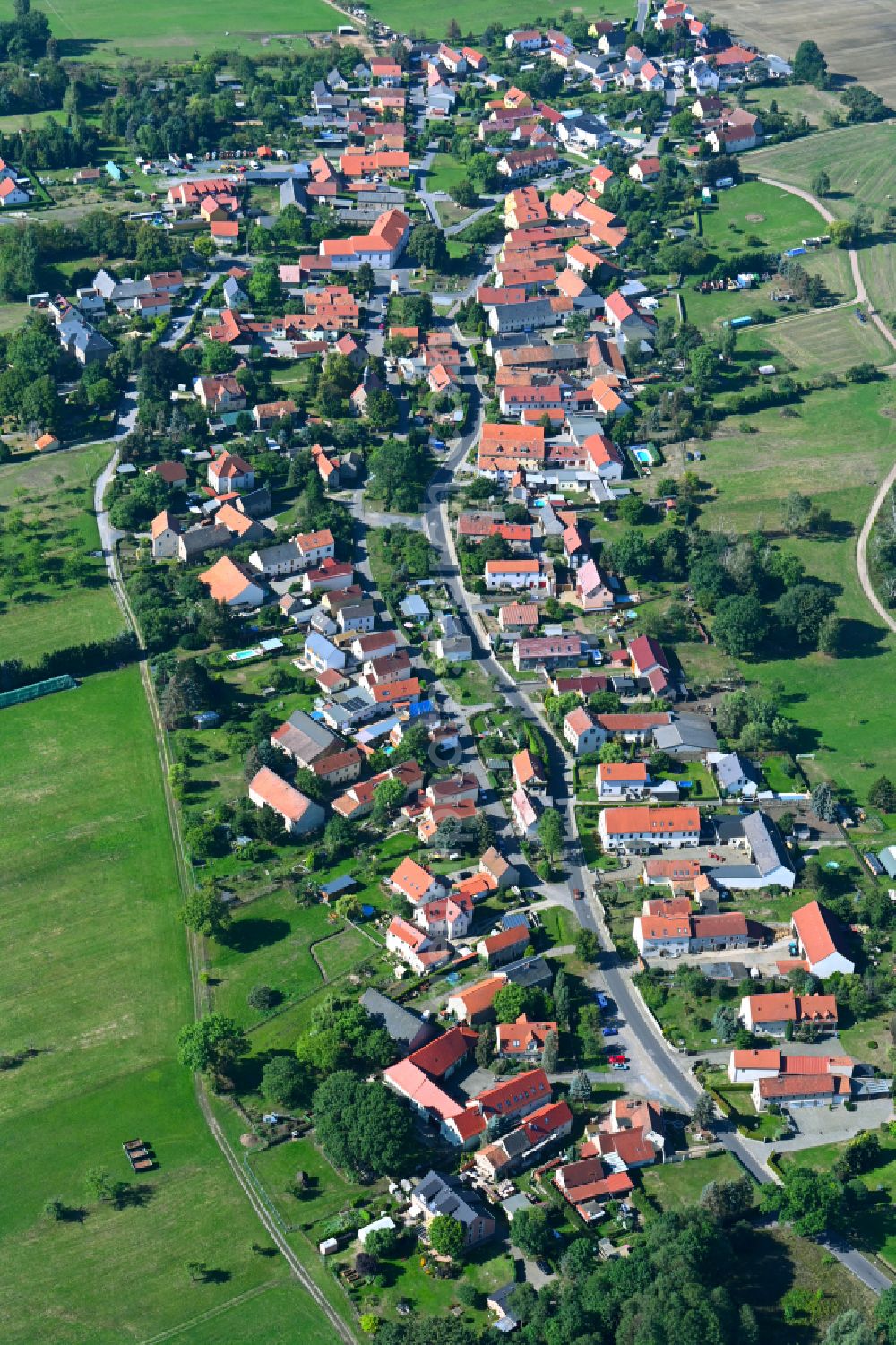 Wilschdorf from above - Agricultural land and field boundaries surround the settlement area of the village on street Kirchstrasse in Wilschdorf in the state Saxony, Germany