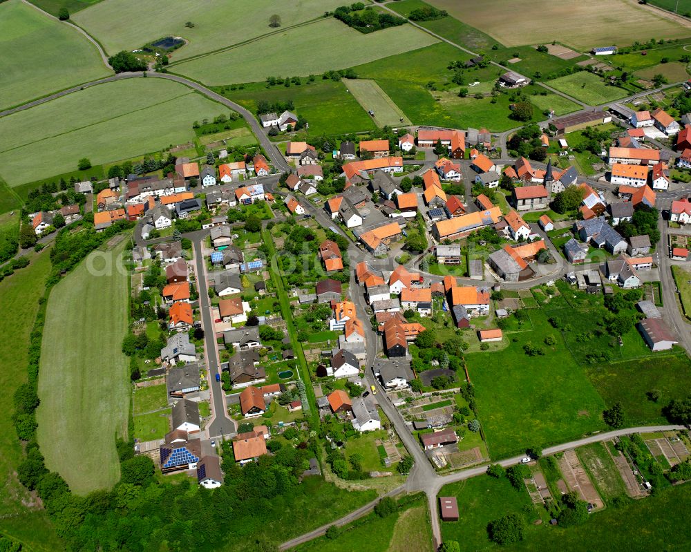 Windhausen from above - Agricultural land and field boundaries surround the settlement area of the village in Windhausen in the state Hesse, Germany