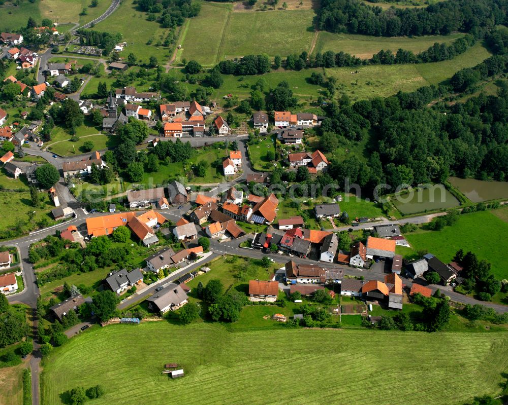 Wingershausen from the bird's eye view: Agricultural land and field boundaries surround the settlement area of the village in Wingershausen in the state Hesse, Germany