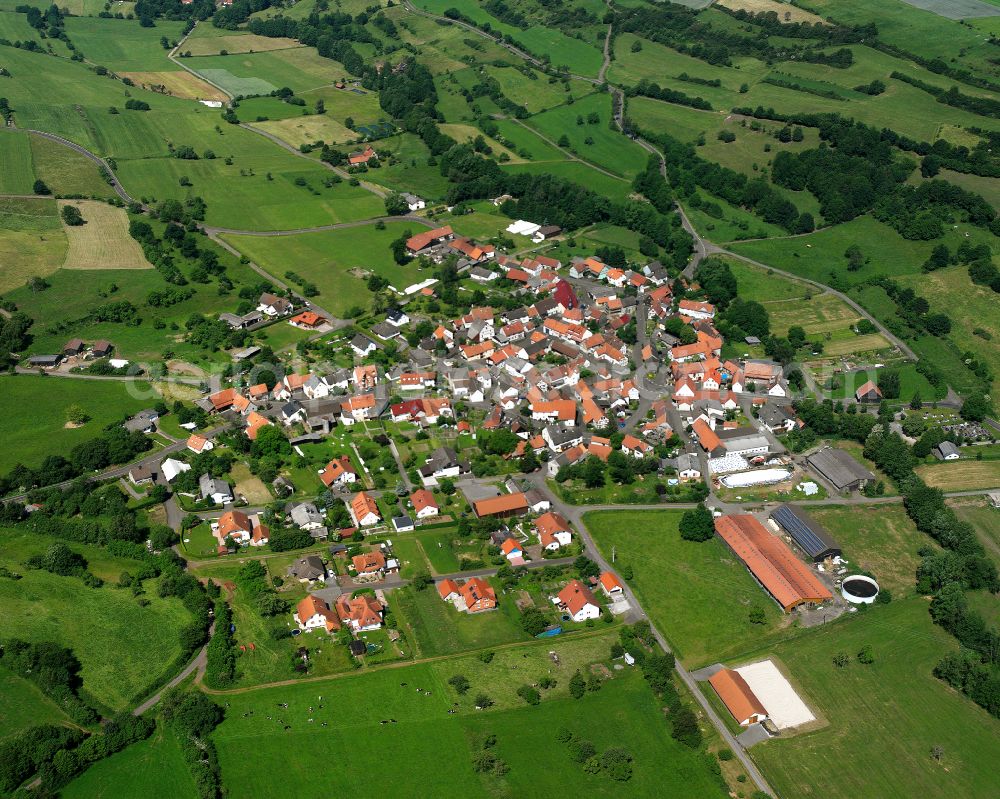 Aerial image Wohnfeld - Agricultural land and field boundaries surround the settlement area of the village in Wohnfeld in the state Hesse, Germany