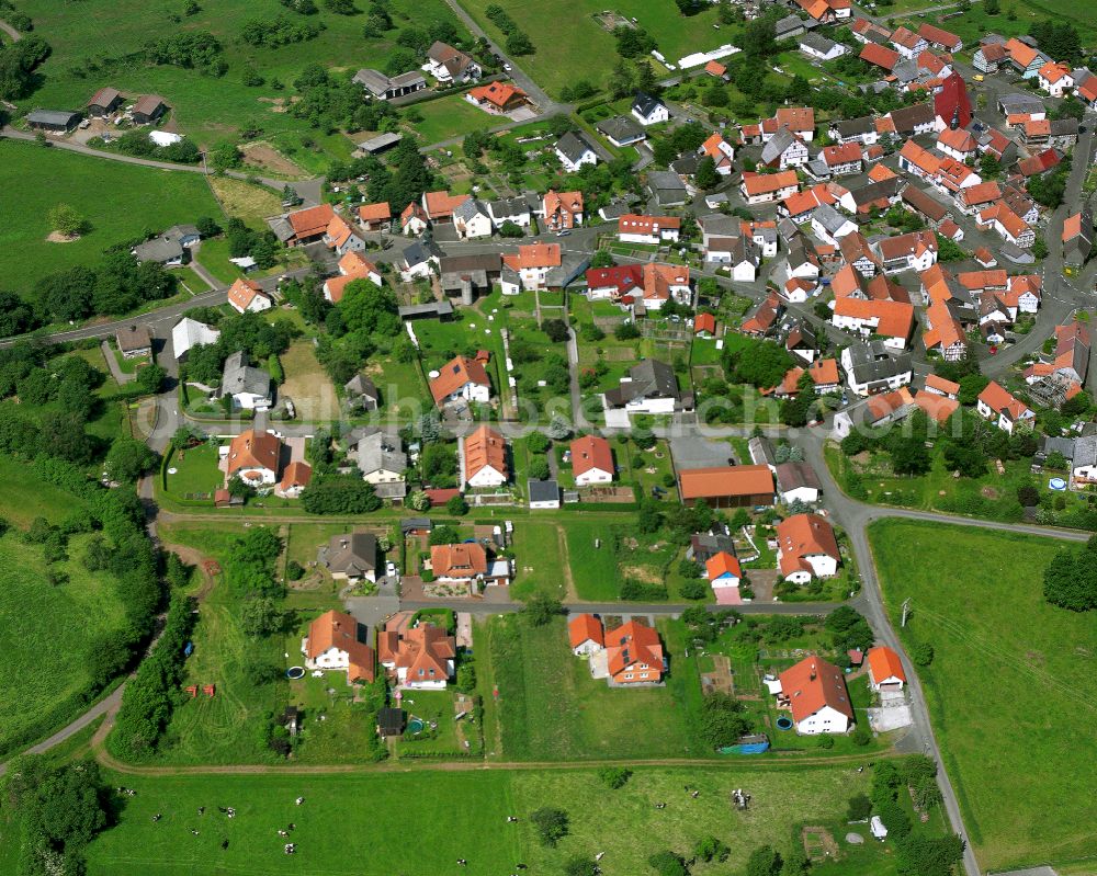 Aerial photograph Wohnfeld - Agricultural land and field boundaries surround the settlement area of the village in Wohnfeld in the state Hesse, Germany