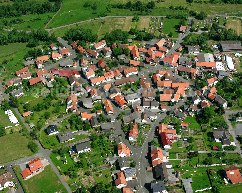 Wohnfeld from above - Agricultural land and field boundaries surround the settlement area of the village in Wohnfeld in the state Hesse, Germany