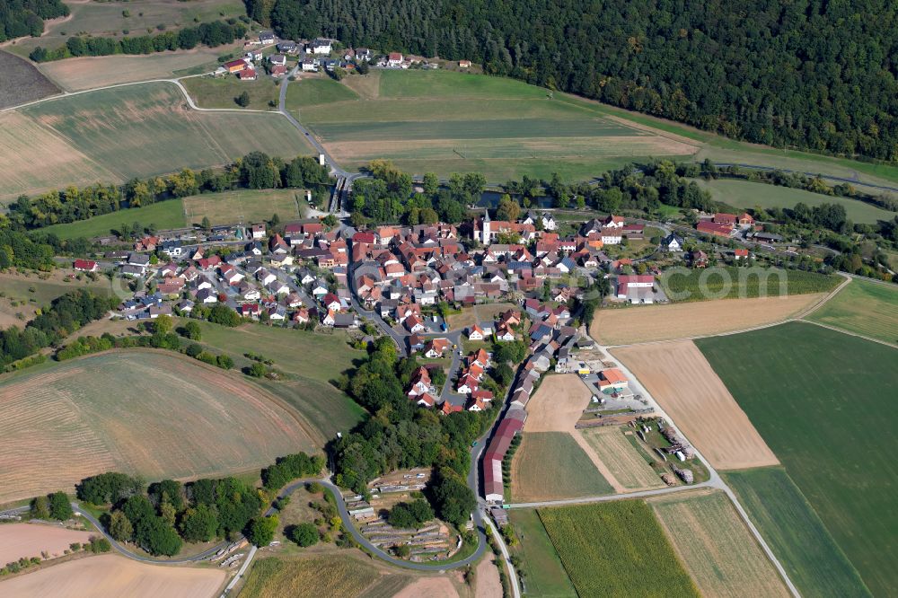 Aerial photograph Wolfsmünster - Agricultural land and field boundaries surround the settlement area of the village in Wolfsmünster in the state Bavaria, Germany