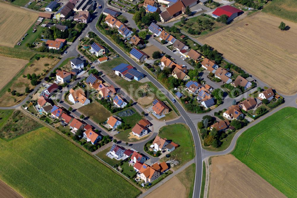 Wolkshausen from the bird's eye view: Agricultural land and field boundaries surround the settlement area of the village in Wolkshausen in the state Bavaria, Germany