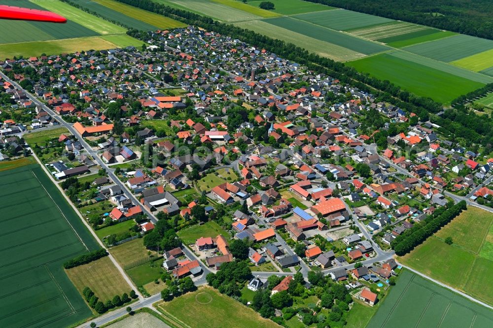 Woltorf from above - Agricultural land and field boundaries surround the settlement area of the village in Woltorf in the state Lower Saxony, Germany