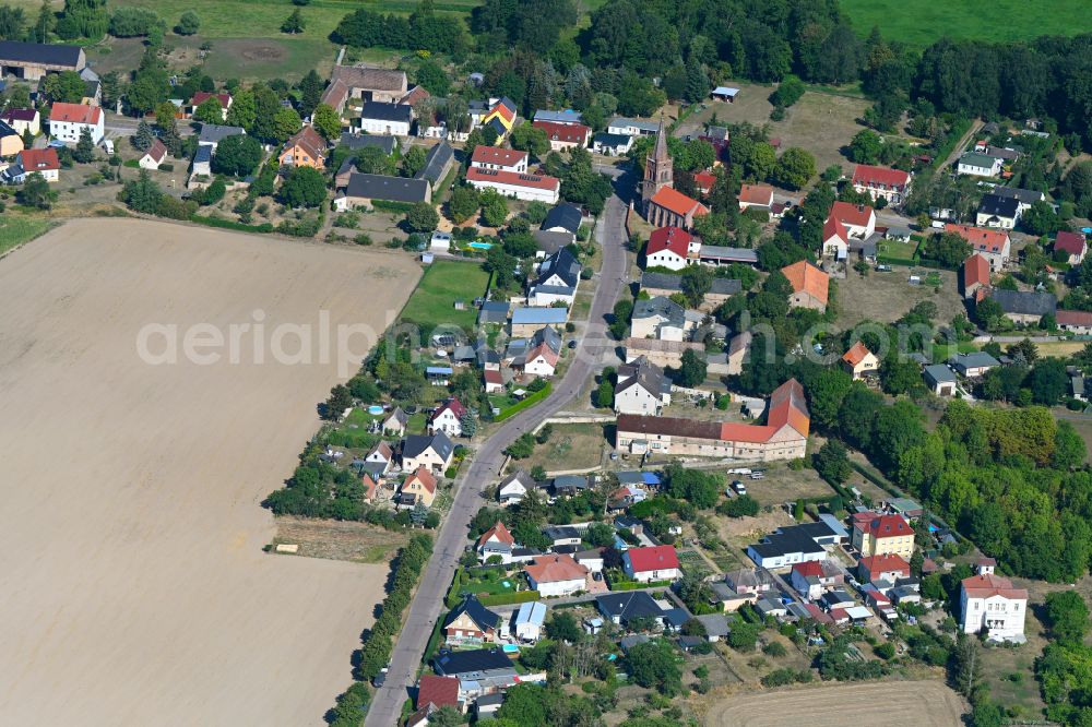 Wust from above - Agricultural land and field boundaries surround the settlement area of the village in Wust in the state Brandenburg, Germany