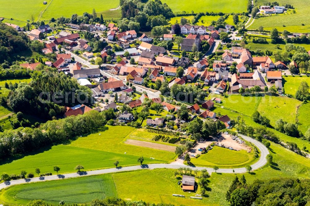 Flechtdorf from above - Agricultural land and field borders surround the settlement area of the village in Flechtdorf in the state Hesse, Germany