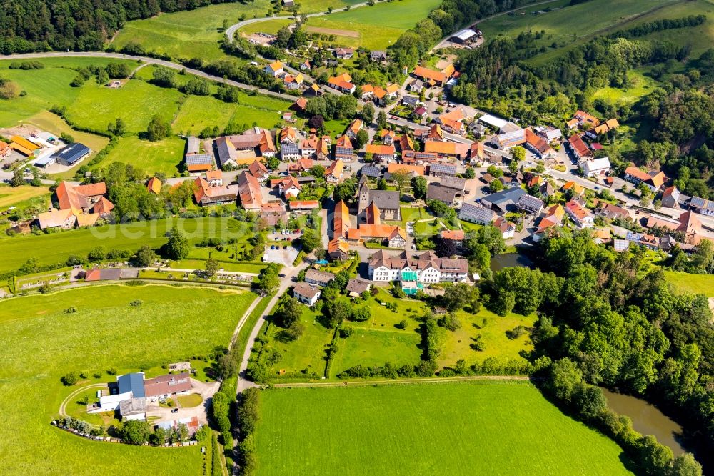 Flechtdorf from the bird's eye view: Agricultural land and field borders surround the settlement area of the village in Flechtdorf in the state Hesse, Germany