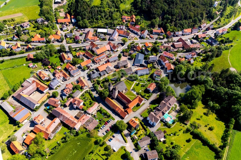 Flechtdorf from above - Agricultural land and field borders surround the settlement area of the village in Flechtdorf in the state Hesse, Germany