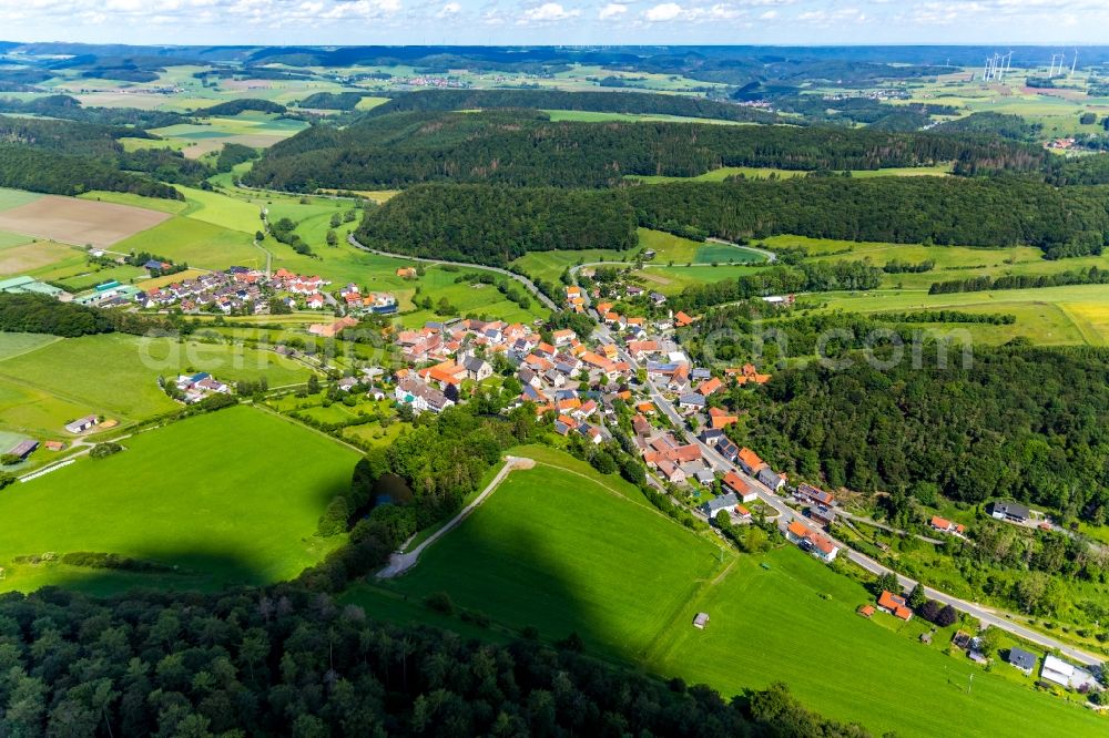 Flechtdorf from the bird's eye view: Agricultural land and field borders surround the settlement area of the village in Flechtdorf in the state Hesse, Germany