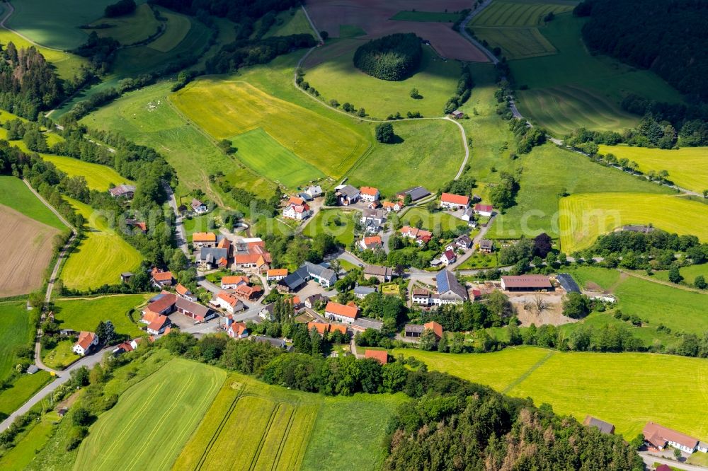 Giebringhausen from above - Agricultural land and field borders surround the settlement area of the village in Giebringhausen in the state Hesse, Germany