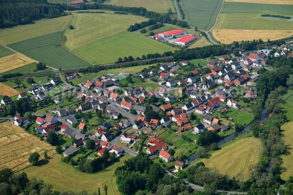 Haueda from the bird's eye view: Agricultural land and field borders surround the settlement area of the village in Haueda in the state Hesse, Germany