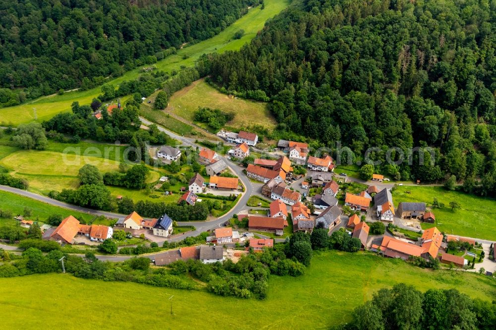 Aerial image Hüddingen - Agricultural land and field borders surround the settlement area of the village in Hueddingen in the state Hesse, Germany