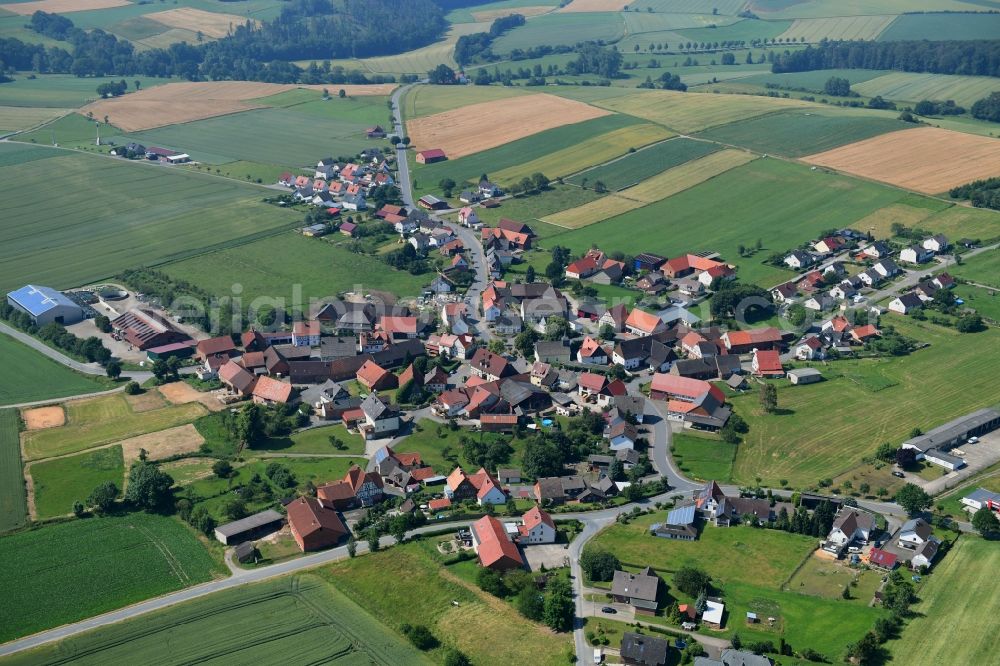 Herbsen from the bird's eye view: Agricultural land and field borders surround the settlement area of the village in Herbsen in the state Hesse, Germany