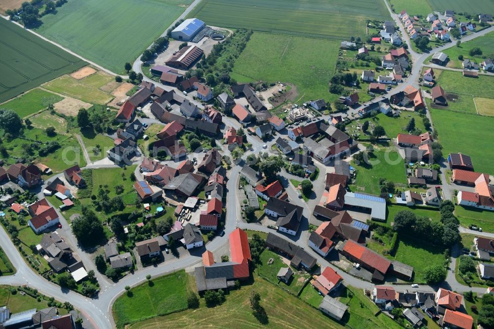 Aerial image Herbsen - Agricultural land and field borders surround the settlement area of the village in Herbsen in the state Hesse, Germany