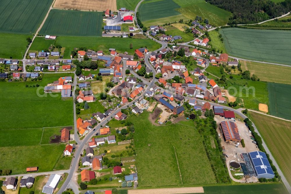 Aerial image Herbsen - Agricultural land and field borders surround the settlement area of the village in Herbsen in the state Hesse, Germany