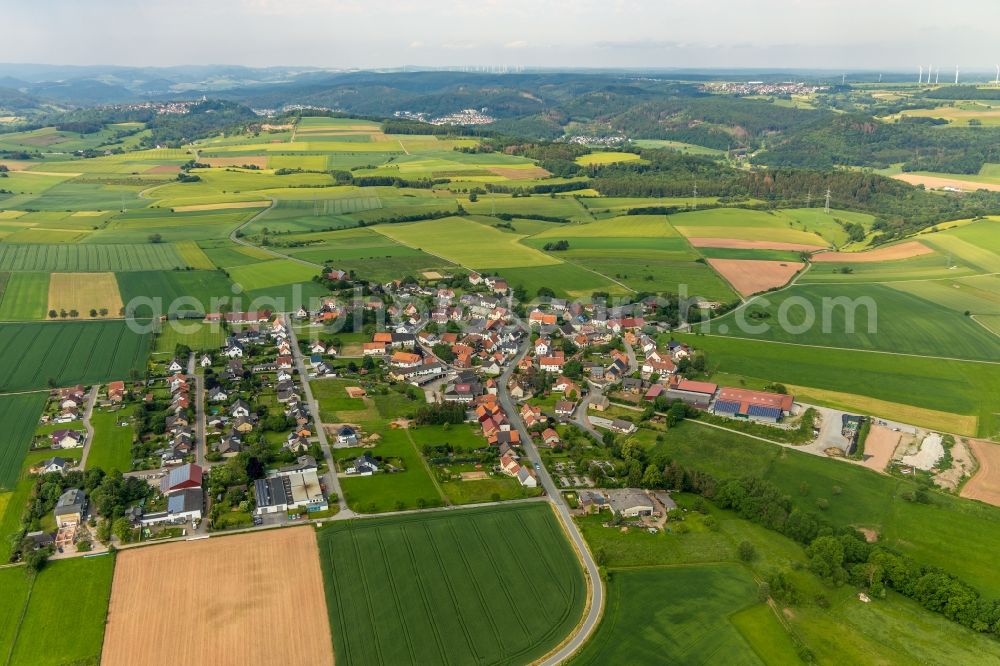 Hesperinghausen from the bird's eye view: Agricultural land and field borders surround the settlement area of the village in Hesperinghausen in the state Hesse, Germany