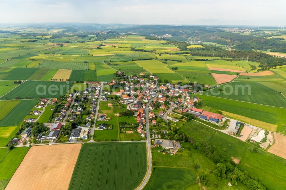 Aerial image Hesperinghausen - Agricultural land and field borders surround the settlement area of the village in Hesperinghausen in the state Hesse, Germany