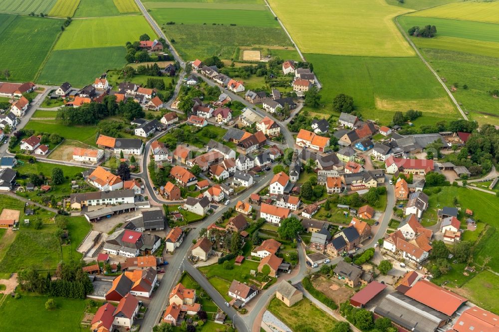 Hesperinghausen from above - Agricultural land and field borders surround the settlement area of the village in Hesperinghausen in the state Hesse, Germany