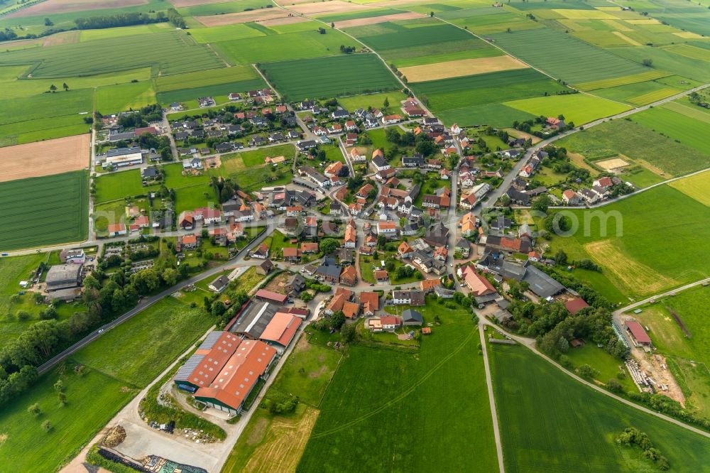 Aerial image Hesperinghausen - Agricultural land and field borders surround the settlement area of the village in Hesperinghausen in the state Hesse, Germany