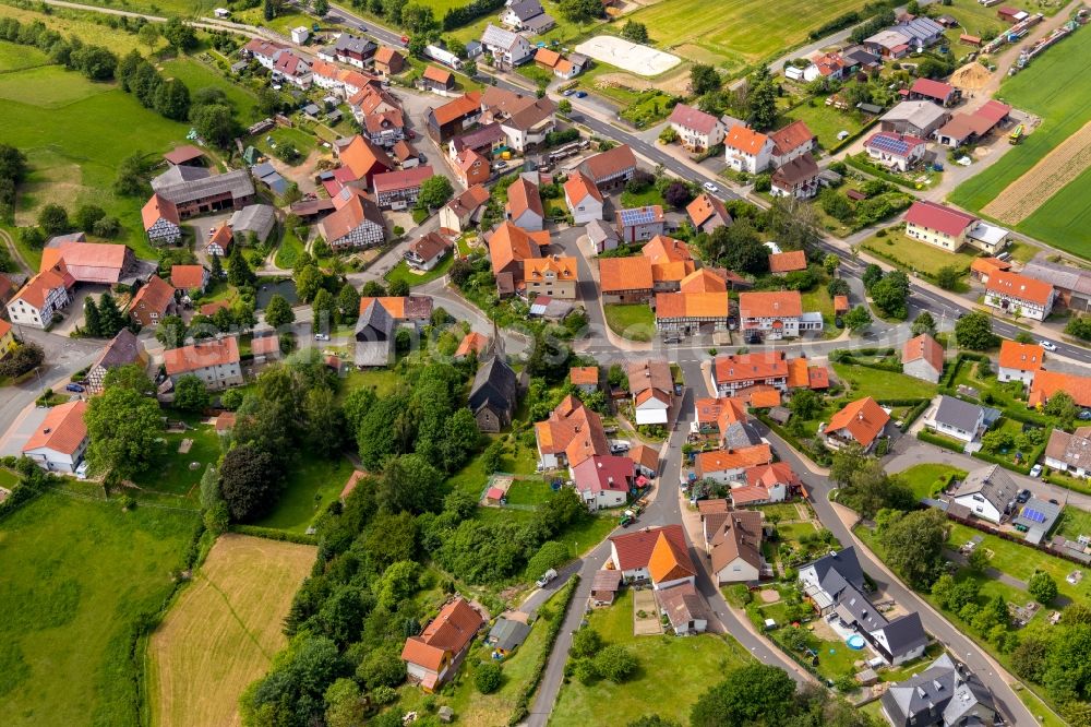 Hundsdorf from above - Agricultural land and field borders surround the settlement area of the village in Hundsdorf in the state Hesse, Germany