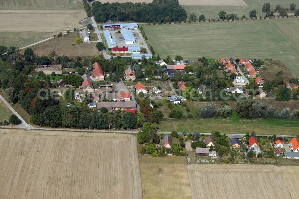 Karlshof from above - Agricultural land and field borders surround the settlement area of the village in Karlshof in the state Brandenburg, Germany