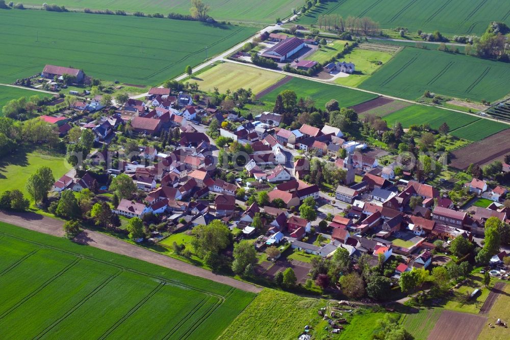 Mehrstedt from the bird's eye view: Agricultural land and field borders surround the settlement area of the village in Mehrstedt in the state Thuringia, Germany