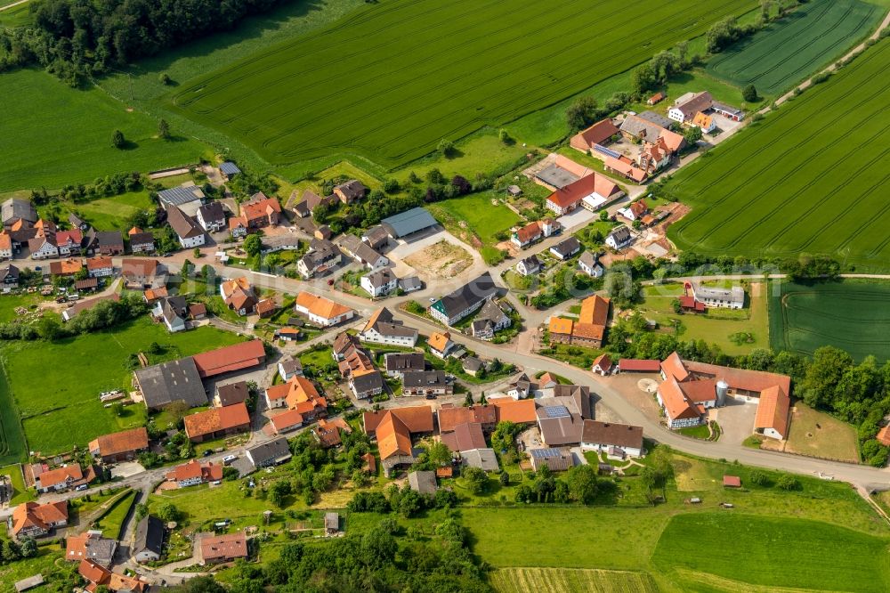 Neudorf from above - Agricultural land and field borders surround the settlement area of the village in Neudorf in the state Hesse, Germany