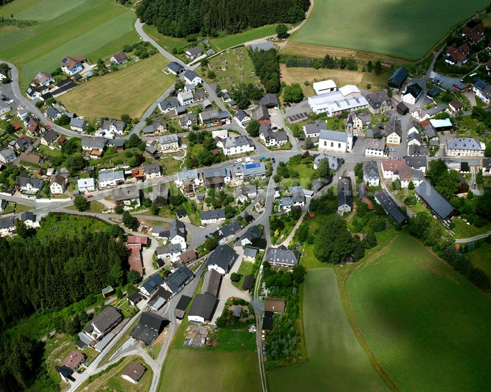 Bernstein a.Wald from above - Agricultural land and field boundaries with the power plants surround the settlement area of the village in Bernstein a.Wald in the state Bavaria, Germany