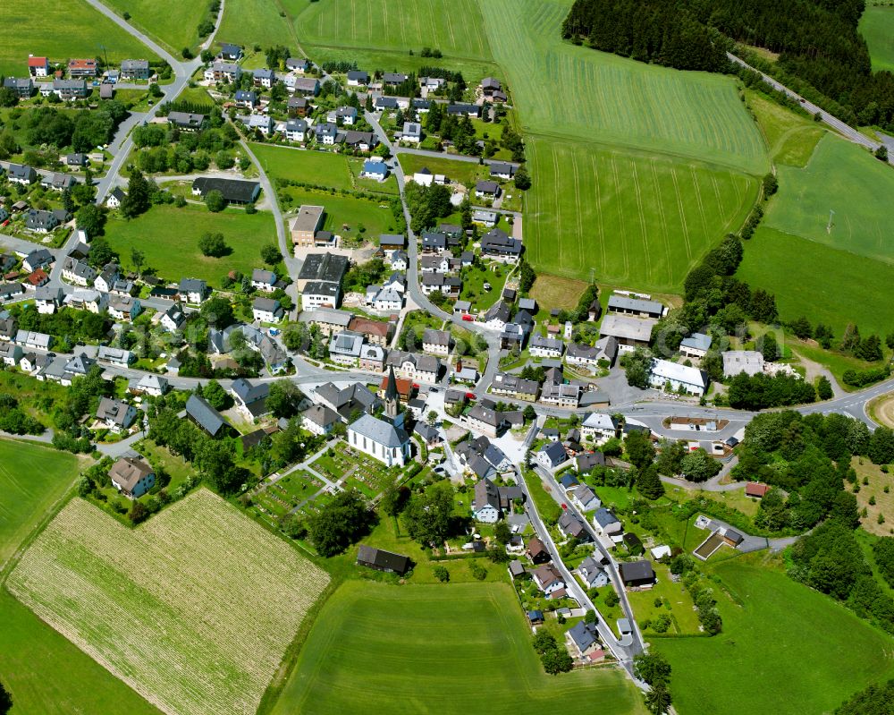 Aerial image Döbra - Agricultural land and field boundaries with the power plants surround the settlement area of the village in Döbra in the state Bavaria, Germany