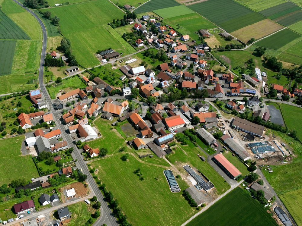 Lichtenau from the bird's eye view: Agricultural land and field boundaries with the power plants surround the settlement area of the village in Lichtenau in the state Baden-Wuerttemberg, Germany