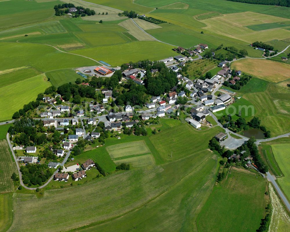 Neuhaus from above - Agricultural land and field boundaries with the power plants surround the settlement area of the village in Neuhaus in the state Bavaria, Germany