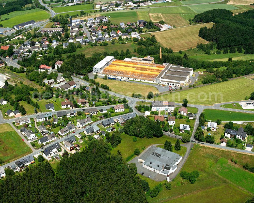 Schwarzenbach am Wald from the bird's eye view: Agricultural land and field boundaries with the power plants surround the settlement area of the village in Schwarzenbach am Wald in the state Bavaria, Germany