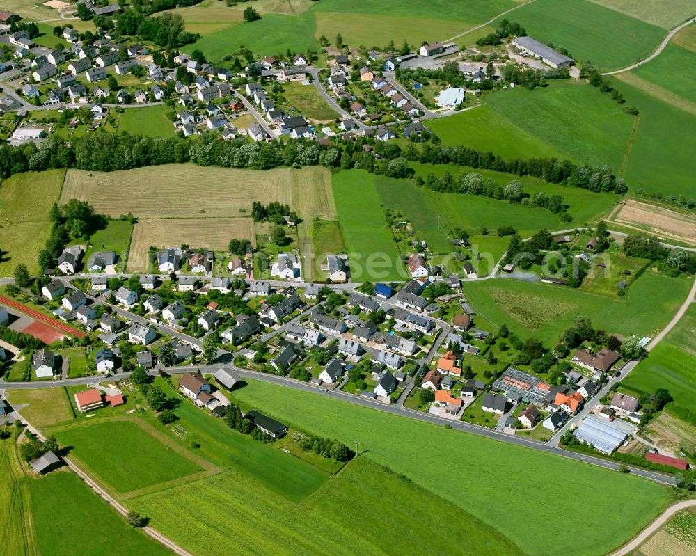 Sparneck from above - Agricultural land and field boundaries with the power plants surround the settlement area of the village in Sparneck in the state Bavaria, Germany