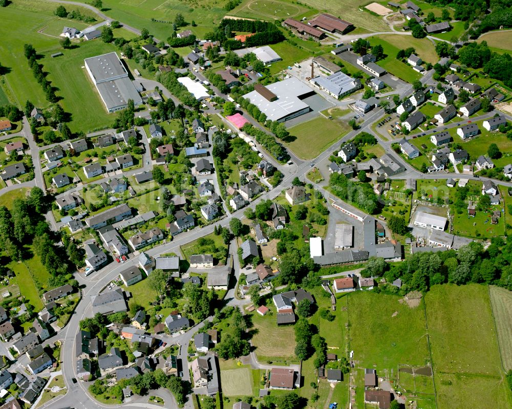 Sparneck from the bird's eye view: Agricultural land and field boundaries with the power plants surround the settlement area of the village in Sparneck in the state Bavaria, Germany