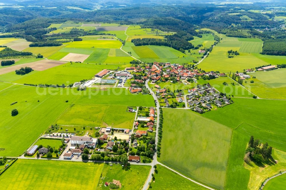 Rhadern from the bird's eye view: Agricultural land and field borders surround the settlement area of the village in Rhadern in the state Hesse, Germany