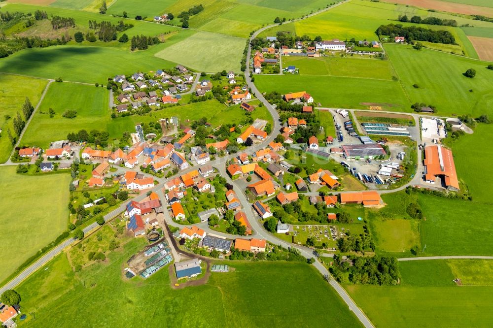 Rhadern from the bird's eye view: Agricultural land and field borders surround the settlement area of the village in Rhadern in the state Hesse, Germany