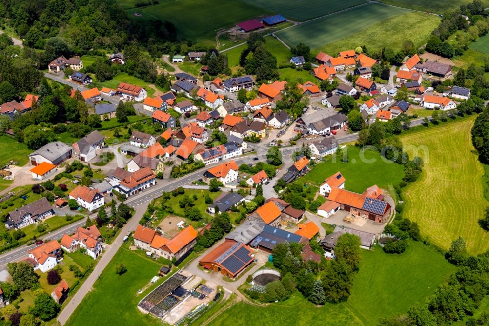 Aerial photograph Rhena - Agricultural land and field borders surround the settlement area of the village in Rhena in the state Hesse, Germany