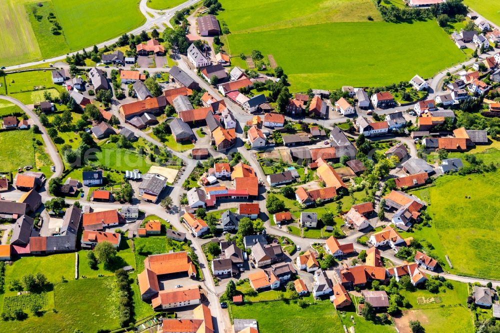 Rhenegge from the bird's eye view: Agricultural land and field borders surround the settlement area of the village in Rhenegge in the state Hesse, Germany