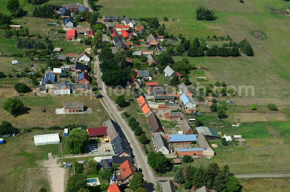 Schilde from above - Agricultural land and field borders surround the settlement area of the village in Schilde in the state Brandenburg, Germany