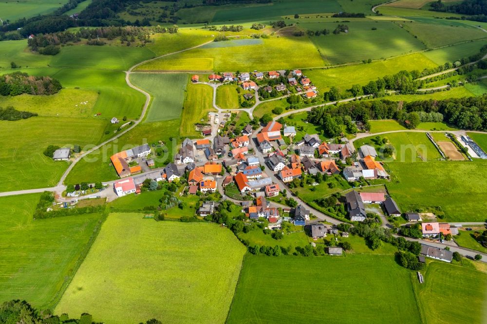 Aerial image Schweinsbühl - Agricultural land and field borders surround the settlement area of the village in Schweinsbuehl in the state Hesse, Germany