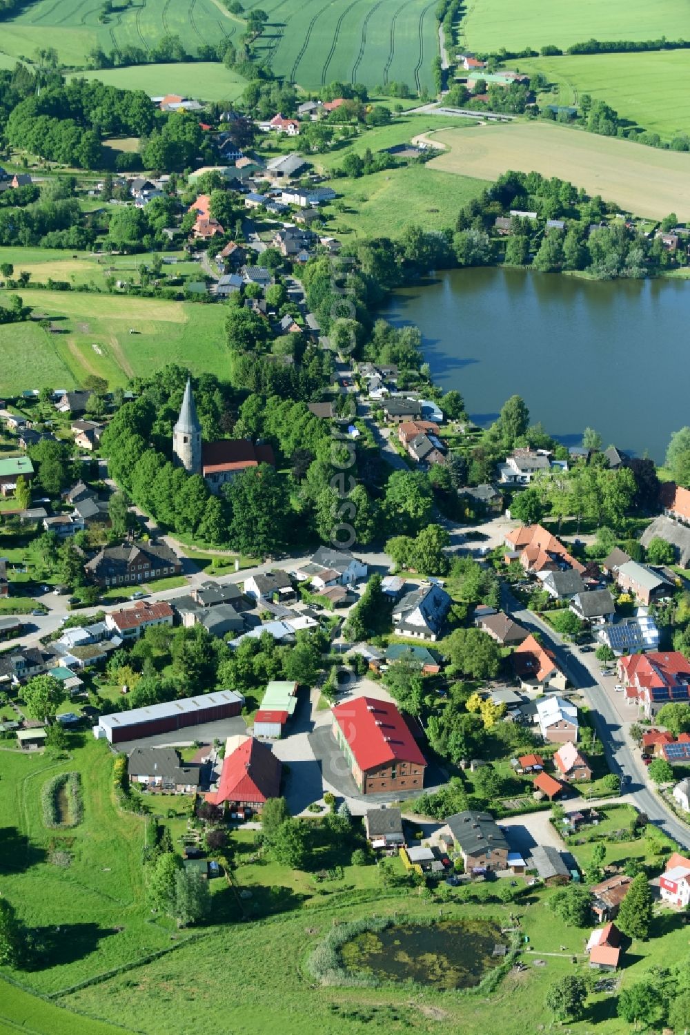 Aerial image Neukirchen - Village on the lake bank areas at the Neukirchener lake in Neukirchen in the state Schleswig-Holstein, Germany