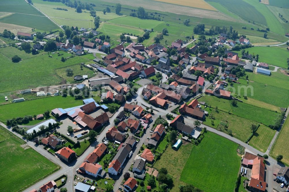 Vasbeck from the bird's eye view: Agricultural land and field borders surround the settlement area of the village in Vasbeck in the state Hesse, Germany