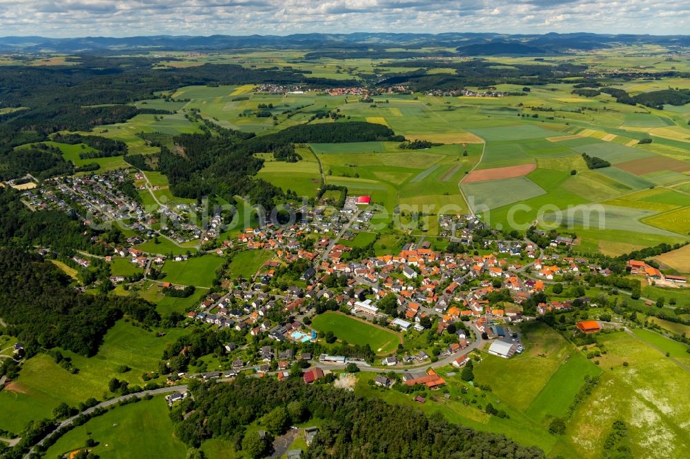 Vöhl from above - Agricultural land and field borders surround the settlement area of the village in Voehl in the state Hesse, Germany