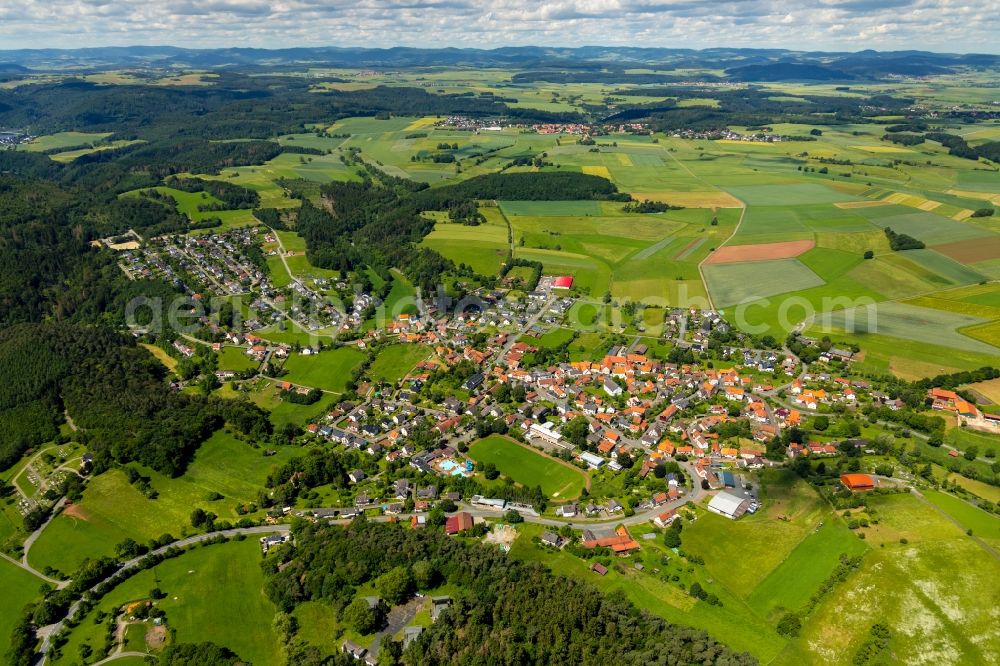 Vöhl from the bird's eye view: Agricultural land and field borders surround the settlement area of the village in Voehl in the state Hesse, Germany